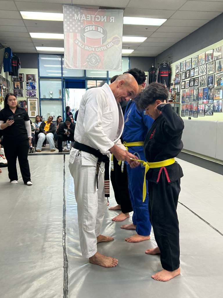 Professor Marcelo promoting student at MCBJJ belt ceremony